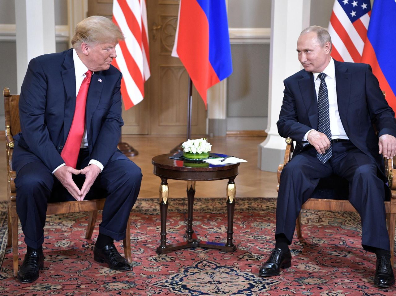 Leaders meeting stage with flags and microphones at an international summit