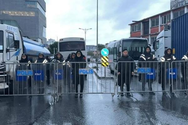 Police vehicles and officers outside a television newsroom entrance in Istanbul during a raid