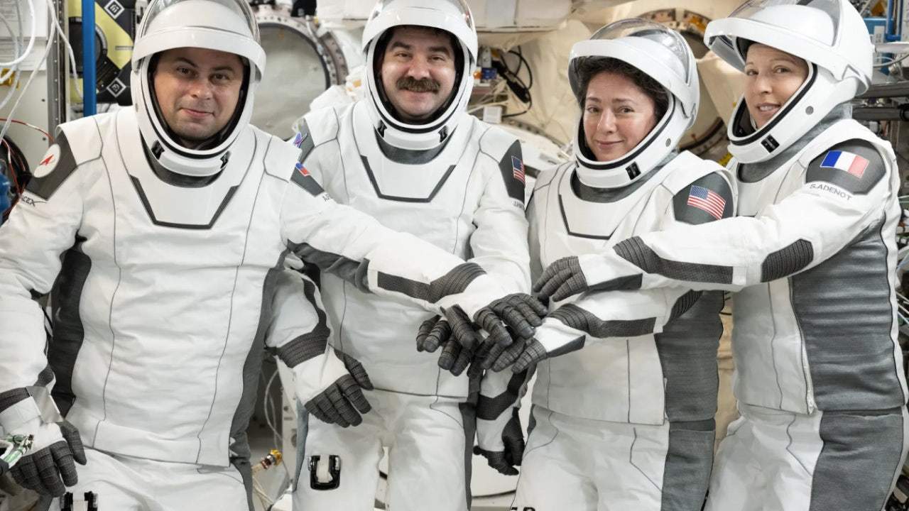 Crew Dragon capsule under parachutes approaching ocean splashdown