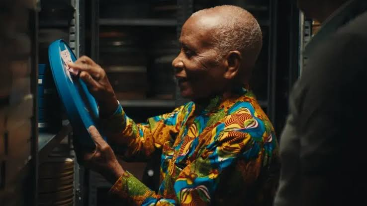 A still from The Eyes of Ghana showing archival film reels and a camera operator.