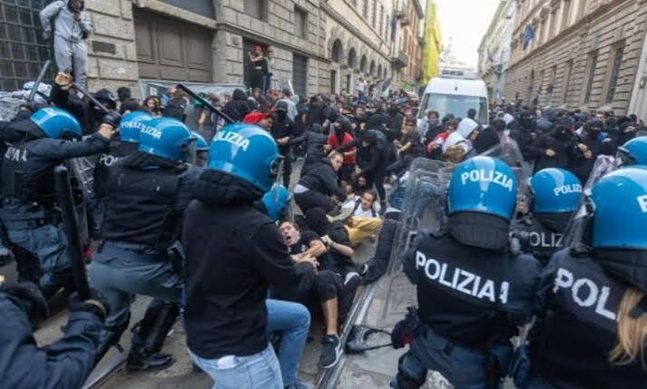 Police patrol near boarded-up shops in central Milan after protests
