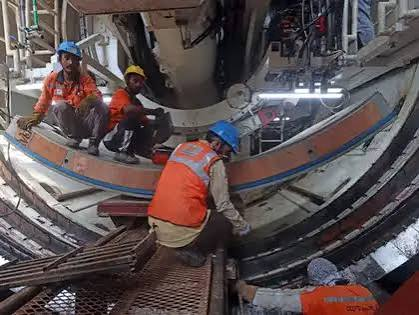 Workers inside an Indian manufacturing facility with equipment and goods in production
