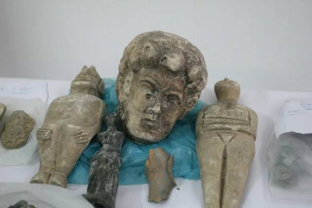 Police investigators inspect seized metal detectors and ancient coins in northern Greece