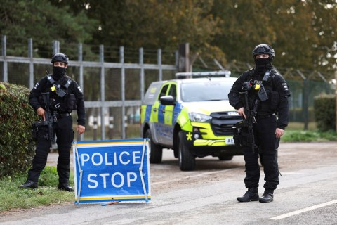 Police activity near a rural airbase with marked vehicles and officers