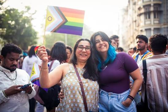 Crowd at Mumbai Pride 2026 with rainbow flags and performers