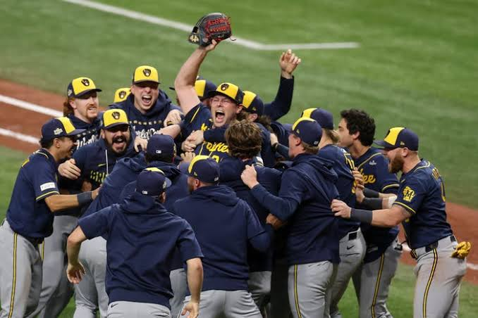Milwaukee Brewers players celebrating on the field at Tropicana Field after Game 5 clincher