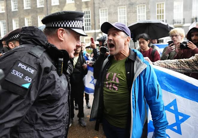 Protesters and police on a street in central London during October 7 demonstrations
